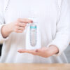 Hands holding a Squeeze bottle with a nipple connected via an adapter