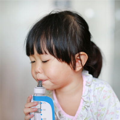 Girl drinking milk from a sippy top