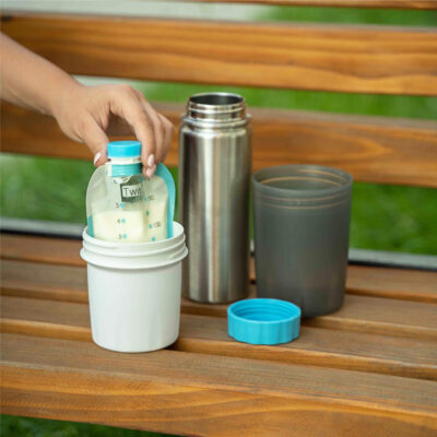 Twist pouch full of milk being warmed in the Travel Warmer on a bench outside